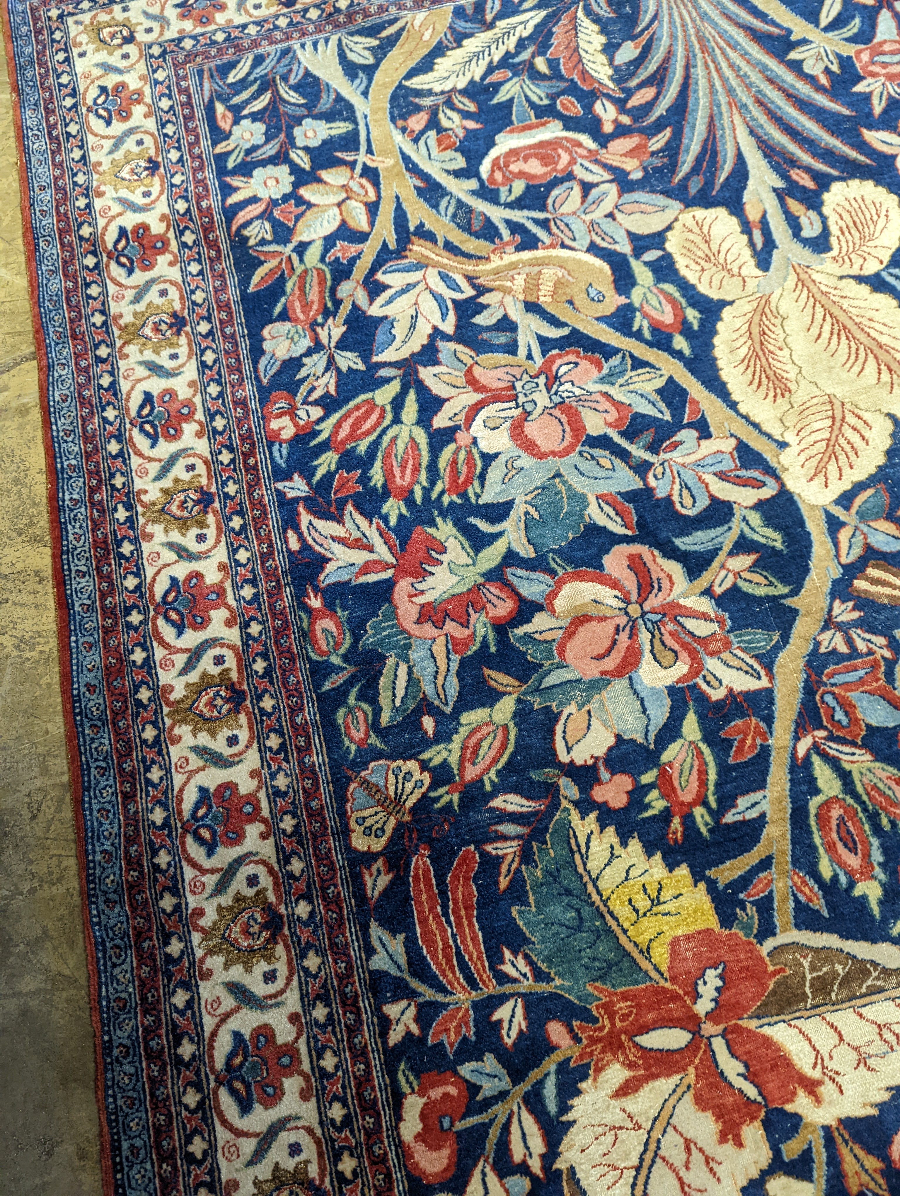 A Kirman blue ground rug woven with birds amongst flowering branches, 205 x 136cm